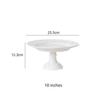 Load image into Gallery viewer, Juliette White Lace Dinnerware by Allthingscurated adds an elegant touch to your tabletop. This sophisticated set is crafted out of ceramic with a beautiful embossed lace rim, giving it a vintage touch. The creamy white pieces come in a dinner plate and cake stand in 2 sizes for easy mixing and matching. They are perfectly sized for a main course, starters and desserts. Featured here is a 10 inches or 25.5cm cake stand with height of 12.3cm or 4.8 inches.