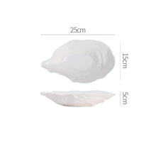 Load image into Gallery viewer, Oyster Shape Serving Dish by Allthingscurated is elegantly crafted in pristine white ceramic to mirror the contours and texture of the elegant oyster. The striking serve ware comes in multiple sizes for plating appetizers or main courses. Seen here is the 25cm or 9.75 inches oyster dish.