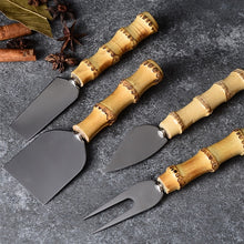 Load image into Gallery viewer, 4-piece Bamboo Cheese Knife Set by Allthingscurated.  Set includes a narrow plane knife, cheese fork, small spade and a flat cheese knife.  Handle is made of natural bamboo and knives of stainless steel.