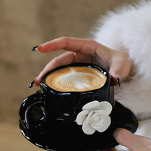 Load image into Gallery viewer, This Camellia Porcelain Cup Set / Mug by Allthingscurated features a single, significant bloom in a timeless black and white design that exudes sophistication. Its high fashion appeal makes it a perfect gift or impressive addition to your high-tea gatherings. Available as a mug or a cup set.