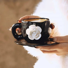 Load image into Gallery viewer, This Camellia Porcelain Cup Set / Mug by Allthingscurated features a single, significant bloom in a timeless black and white design that exudes sophistication. Its high fashion appeal makes it a perfect gift or impressive addition to your high-tea gatherings. Available as a mug or a cup set. Featured here is the Camellia Cup with Saucer set.