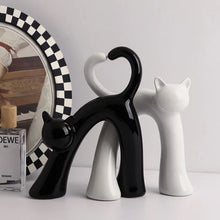 Load image into Gallery viewer, These Cat Couple Love Figurines by Allthingscurated are perfect for cat lovers. Made of ceramic, they feature a pair of cute and whimsical cats in contrasting colors, with their tails entwined to form a heart shape. A romantic and unique gift for any occasion.