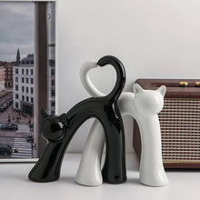 Load image into Gallery viewer, These Cat Couple Love Figurines by Allthingscurated are perfect for cat lovers. Made of ceramic, they feature a pair of cute and whimsical cats in contrasting colors, with their tails entwined to form a heart shape. A romantic and unique gift for any occasion.