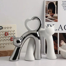 Load image into Gallery viewer, These Cat Couple Love Figurines by Allthingscurated are perfect for cat lovers. Made of ceramic, they feature a pair of cute and whimsical cats in contrasting colors, with their tails entwined to form a heart shape. A romantic and unique gift for any occasion.