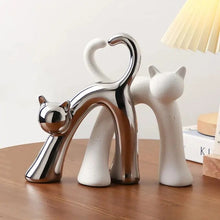 Load image into Gallery viewer, These Cat Couple Love Figurines by Allthingscurated are perfect for cat lovers. Made of ceramic, they feature a pair of cute and whimsical cats in contrasting colors, with their tails entwined to form a heart shape. A romantic and unique gift for any occasion.