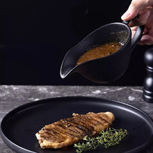 Load image into Gallery viewer, Curtis Ceramic Gravy Boat by Allthingscurated features an easy-to-hold handle and a narrow spout to ensure precise pouring without spills and drips. Available in white with a smooth, shiny glaze or black with a matte, rough finish. This versatile serveware with a capacity of 220ml or 7.4 fluid ounce is perfect for any occasion, formal or casual.