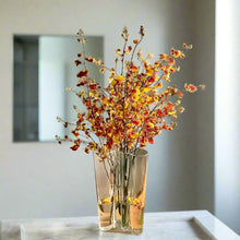 Load image into Gallery viewer, Amber Vase with autumn-themed floral arrangement on a marble surface. The Dayton Vase by Allthingscurated offers a beautiful asymmetrical design that feels both timeless and organic. Its sculptural, minimalist form brings a striking yet harmonious touch to any home interior. Available in clear, green and amber, it’s an unforgettable gift for housewarmings, weddings or holidays.