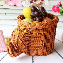 Load image into Gallery viewer, Wicker elephant-shaped basket with fruits on a white surface by Allthingscurated