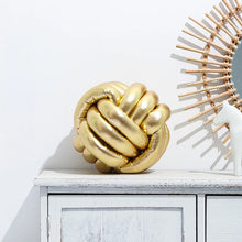 Load image into Gallery viewer, Metallic Color Knot Ball Cushions by Allthingscurated come in a metallic palette of Gold, Silver and Red. These cushions will give your home a trendy update easily with their bold design and bring attention to your favorite sofa or chair. Their unique spherical shape and eye-catching colors will add a stylish and sculptural touch to your living space.