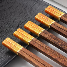 Load image into Gallery viewer, Faux Jade Wooden Chopsticks by Allthingscurated feature five striking colors with jade embellishment crafted from high-grade resin that is contemporary in design yet practical in everyday dining or special occasions. Come as a set of 5 pairs or 10 pairs. Shown here is a set in Golden Yellow.