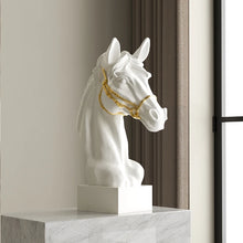 Load image into Gallery viewer, White horse head sculpture with gold bridle on a marble surface. Fargo Horse Head Bust by Allthingscurated is an elegant decorative sculpture with meticulous detail and flaunts a gorgeous gold-accented bridle. Perfect for horse enthusiasts and makes a meaningful gift for those born under the Horse zodiac sign. And expertly crafted to complement both timeless classic and contemporary modern interiors.