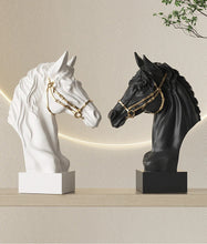Load image into Gallery viewer, White and black horse busts with gold bridles on a shelf against a beige wall. Fargo Horse Head Bust by Allthingscurated is an elegant decorative sculpture with meticulous detail and flaunts a gorgeous gold-accented bridle. Perfect for horse enthusiasts and makes a meaningful gift for those born under the Horse zodiac sign. And expertly crafted to complement both timeless classic and contemporary modern interiors.