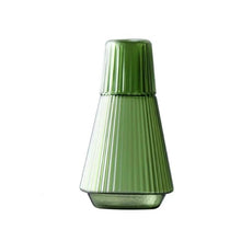 Load image into Gallery viewer, Hanis Fluted Bedside Water Carafe by Allthingscurated has a generous capacity of 1000 ml or 33.8 fluid ounce. Its minimalist design boats a fluted body and distinctive conical shape, making it a stylish drinkware that is also a beautiful home décor piece. Crafted from durable, heat-resistant glass for long-lasting use. Choose from 4 stunning colors in Amber, Blue, Green and Black. Each carafe comes with matching cover that doubles as a drinking cup. Featured here is carafe in Green.