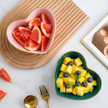 Load image into Gallery viewer, Heart-shaped bowls with sliced grapefruit and fruit salad on a wooden board. Gold-rimmed Heart Shape Ceramic Bowl by Allthingscurated is a beautiful and versatile piece to own in your dinnerware collection. Perfect for salads, desserts and appetizers, its charming design adds an extra touch of romance for Valentine’s Day dinner; and make everyday meals extra special.