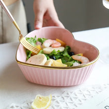 Load image into Gallery viewer, Pink bowl with salad and a lemon wedge on a white tablecloth. Gold-rimmed Heart Shape Ceramic Bowl by Allthingscurated is a beautiful and versatile piece to own in your dinnerware collection. Perfect for salads, desserts and appetizers, its charming design adds an extra touch of romance for Valentine’s Day dinner; and make everyday meals extra special.