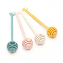 Load image into Gallery viewer, Pastel Hand Wand Honey Dippers by Allthingscurated come in 4 charming pastel colors of blue, pink, yellow and white. The unique dipper features a long handle that ends with a hand design at the tip. Made of high-quality material for durability and practical use, the rounded head with deep grooves makes for optimal dispensing, perfect for honey toasts and drinks.