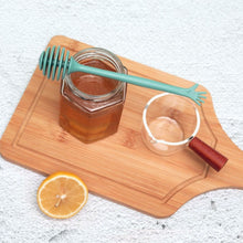 Load image into Gallery viewer, Pastel Hand Wand Honey Dippers by Allthingscurated come in 4 charming pastel colors of blue, pink, yellow and white. The unique dipper features a long handle that ends with a hand design at the tip. Made of high-quality material for durability and practical use, the rounded head with deep grooves makes for optimal dispensing, perfect for honey toasts and drinks.