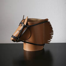 Load image into Gallery viewer, Product feature here is a brown faux leather horse-shaped organizer with black straps and fringe details, displayed on a dark reflective surface against a light gray wall.