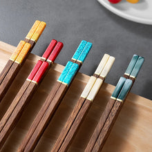 Load image into Gallery viewer, Set of colorful chopsticks on a wooden board with a gray background. Faux Jade Wooden Chopsticks by Allthingscurated feature five striking colors with jade embellishment crafted from high-grade resin that is contemporary in design yet practical in everyday dining or special occasions. Come as a set of 5 pairs or 10 pairs.