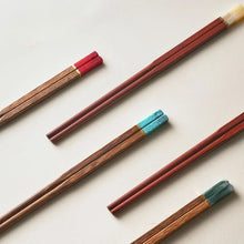 Load image into Gallery viewer, Set of wooden chopsticks with colored tips on a light background. Faux Jade Wooden Chopsticks by Allthingscurated feature five striking colors with jade embellishment crafted from high-grade resin that is contemporary in design yet practical in everyday dining or special occasions. Come as a set of 5 pairs or 10 pairs.
