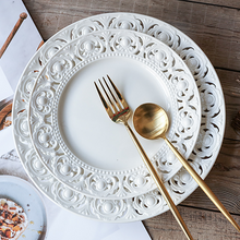 Load image into Gallery viewer, Juliette White Lace Dinnerware by Allthingscurated adds an elegant touch to your tabletop. This sophisticated set is crafted out of ceramic with a beautiful embossed lace rim, giving it a vintage touch. The creamy white pieces come in a dinner plate and cake stand in 2 sizes for easy mixing and matching. They are perfectly sized for a main course, starters and desserts.