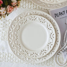 Load image into Gallery viewer, Juliette White Lace Dinnerware by Allthingscurated adds an elegant touch to your tabletop. This sophisticated set is crafted out of ceramic with a beautiful embossed lace rim, giving it a vintage touch. The creamy white pieces come in a dinner plate and cake stand in 2 sizes for easy mixing and matching. They are perfectly sized for a main course, starters and desserts.