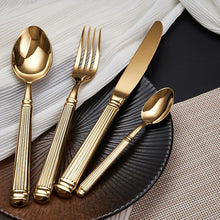 Load image into Gallery viewer, Julius Gold Stainless Steel Flatware Sets by Allthingscurated are crafted from high-quality 18/10 stainless steel. The weighty and solid construction provides a luxurious feel, while the Roman column handle design adds a touch of elegance. The mirror polished surface reflects a bright and shiny finish, adding a touch of sophistication to any table.