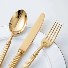 Load image into Gallery viewer, Julius Gold Stainless Steel Flatware Sets by Allthingscurated are crafted from high-quality 18/10 stainless steel. The weighty and solid construction provides a luxurious feel, while the Roman column handle design adds a touch of elegance. The mirror polished surface reflects a bright and shiny finish, adding a touch of sophistication to any table.