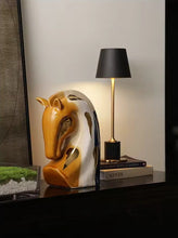 Load image into Gallery viewer, Decorative horse head sculpture on a shelf with a lamp in the background. Jyunma Ceramic Horse by Allthingscurated is handmade artistry at its finest. It’s more than just decoration, it embodies auspiciousness and prosperity; represents steadfast loyalty and protective guardianship through time. Its elegance makes it a perfect gift for any horse enthusiasts or anyone born under the Chinese zodiac sign of the horse; and an exquisite addition to any contemporary home for its enduring appeal.