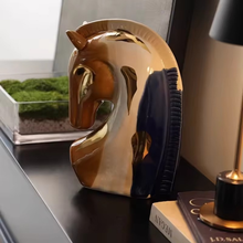 Load image into Gallery viewer, Decorative horse sculpture on a shelf with books and a plant in the background. Jyunma Ceramic Horse by Allthingscurated is handmade artistry at its finest. It’s more than just decoration, it embodies auspiciousness and prosperity; represents steadfast loyalty and protective guardianship through time. Its elegance makes it a perfect gift for any horse enthusiasts or anyone born under the Chinese zodiac sign of the horse; and an exquisite addition to any contemporary home for its enduring appeal.