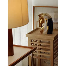 Load image into Gallery viewer, Horse head sculpture on a wooden shelf with a lamp and framed poster in the background. Jyunma Ceramic Horse by Allthingscurated is handmade artistry at its finest. It’s more than just decoration, it embodies auspiciousness and prosperity; represents steadfast loyalty and protective guardianship through time. Its elegance makes it a perfect gift for any horse enthusiasts or anyone born under the Chinese zodiac sign of the horse; and an exquisite addition to any contemporary home for its enduring appeal.