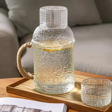 Load image into Gallery viewer, Kiv Hammered Glass Pitcher with Cover in 2 liter or 68 ounce capacity by Allthingscurated. Comes with a hemp rope handle for a rustic vibe. Large capacity and heat-resistant. It's the perfect thirst quencher for summer.
