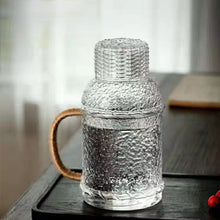 Load image into Gallery viewer, Kiv Hammered Glass Pitcher with Cover in 2 liter or 68 ounce capacity by Allthingscurated. Comes with a hemp rope handle for a rustic vibe. Large capacity and heat-resistant. It's the perfect thirst quencher for summer.