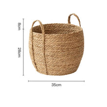 Load image into Gallery viewer, Leedon Woven Baskets by Allthingscurated are hand-woven from seagrass which is an eco-friendly material. The baskets feature sturdy handles for easy transportation and lend a rustic charm to any space. Perfect for storing household items or displaying your favorite plants. Available in 3 sizes. Featured here is the large basket measuring 28cm or 11 inches in height and 35cm or 13.7 inches in width.