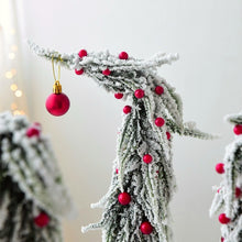 Load image into Gallery viewer, Snow Flocked Grinch Christmas Trees by Allthingscurated feature bending trees with a touch of quirkiness. The abstract design is both unconventional and whimsical. These snow-covered trees are decorated with crimson red baubles that will transform your home into a winter wonderland. Available in 2 sizes.