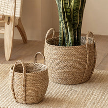 Load image into Gallery viewer, Leedon Woven Baskets by Allthingscurated are hand-woven from seagrass which is an eco-friendly material. The baskets feature sturdy handles for easy transportation and lend a rustic charm to any space. Perfect for storing household items or displaying your favorite plants. Available in 3 sizes.