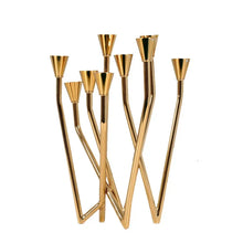 Load image into Gallery viewer, Lysa Gold Candelabra by Allthingscurated spots an asymmetrical design and clean lines that exude modern elegance. With 9 arms for taper candles, the gold-tone metal surface reflects the glow of the flames, creating a warm and captivating atmosphere. It’s stunning centerpiece for any occasion and decorative accent for any event or space.
