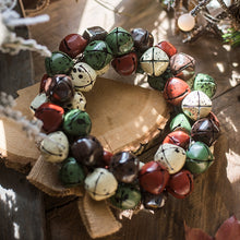 Load image into Gallery viewer, Christmas Jingle Bells Wreath by Allthingscurated comes in 3 semi-matte colors of Red, Multi Colors and Gold. The Multi Color Wreath features clusters of bell in green, red, ivory and brown. Each wreath is formed of bells made of iron entwined onto a jute rope and truly jingle with each movement. Measures approximately 18cm or 7 inches in width and height.
