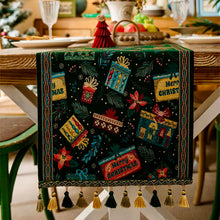 Load image into Gallery viewer, Decorative Christmas table runner with tassels on a table setting. Elevate your holiday entertaining with this Merry Christmas Jacquard Table Runner by Allthingscurated. Inspired by the joy of gift-giving, this table runner features an array of gift box motifs rendered in rich jewel tones, this piece showcases beautiful embroidery complemented by pretty tassels. Perfect for elevating your holiday tablescape, making every feast and gathering truly memorable.
