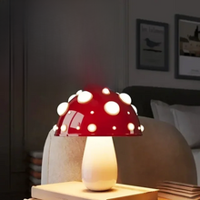Load image into Gallery viewer, Whimsical Mushroom LED Lamp by Allthingscurated is unique and decorative, yet functional. The enchanting design features a playful mushroom silhouette, complete with red-capped spots lampshade to bring a touch of whimsy to any room. It makes a perfect gift for someone with a special affinity for mushrooms. Comes in a cordless and corded version with 2 lamp base colors. Featured here is the small lamp with white base.