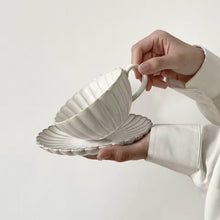 Load image into Gallery viewer, Japanese Chrysanthemum Cup and Saucer by Allthingscurated is inspired by the flower’s perfect symmetry and stunning beauty in the Japanese culture. Crafted from porcelain, it’s a beautiful set to entertain friends and family for afternoon teas at home. This is an Off-white cup and saucer set.