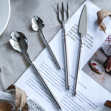 Load image into Gallery viewer, Neptune 4-piece Flatware Set by Allthingscurated beautifully blends mythical design with modern construction. Made from high-quality 18/10 stainless steel with a sleek mirror polishing for a modern look. Inspired by Poseidon’s Trident, the dinner fork is expertly shaped to resemble the 3-pronged spear. Unique and elegant, the place setting comes in silver, gold, rose gold, black and colorful rainbow and each set consists of a dinner spoon, dinner fork, dinner knife and a small spoon.