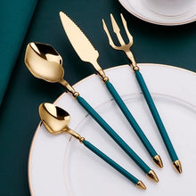 Load image into Gallery viewer, Neptune 4-piece Colored Handle Luxury Flatware Set by Allthingscurated beautifully blends mythical design with modern construction. Made from high-quality 18/10 stainless steel with a sleek mirror polishing for a modern look. Inspired by Poseidon’s Trident, the dinner fork is expertly shaped to resemble the 3-pronged spear. This place setting comes in Gold with either black, white, turquoise blue and green handle. Each set consists of a dinner spoon, dinner fork, dinner knife and a small spoon.