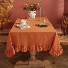 Load image into Gallery viewer, Introducing Ruffled Cotton Tablecloth by Allthingscurated. Made from 100% cotton, our tablecloth exudes French country charm with its romantic, frilly ruffles. With the perfect balance of decorative and laid-back, they have a welcoming and comforting vibe. Available in 8 solid colors. Featured here is the Orange tablecloth.