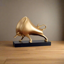 Load image into Gallery viewer, The Oscar Bull Sculpture by Allthingscurated spots an abstract and contemporary design in a matte gold finish. This stunning piece makes the perfect gift for those born under the zodiac ox sign and Taurus. It not only serves as a beautiful display but also adds a touch of personality.