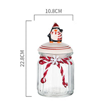 Load image into Gallery viewer, Christmas Festive Storage Jars by Allthingscurated are the perfect jars to keep all your festive treats fresh and delicious. The jars are airtight and each jar is topped with a ceramic lid decorated with a Santa Claus, Christmas Tree, Penguin, Gnome or Fox. Comes in 2 sizes with capacity of 300ml or 10 ounce and 1000ml or 34 ounce. Featured here is a large Penguin jar.