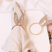 Load image into Gallery viewer, These sparkling Bunny Ear Napkin Rings (set of 6) by Allthingscurated add a cute and whimsical touch to your Easter table setting. Made of metal and encrusted with rhinestones, they come in gold, silver, and rose gold. Elevate your dining experience with these charming and sparkly napkin rings.