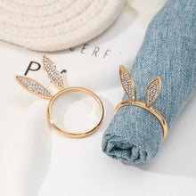 Load image into Gallery viewer, These sparkling Bunny Ear Napkin Rings (set of 6) by Allthingscurated add a cute and whimsical touch to your Easter table setting. Made of metal and encrusted with rhinestones, they come in gold, silver, and rose gold. Elevate your dining experience with these charming and sparkly napkin rings.