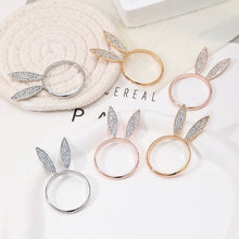 Load image into Gallery viewer, These sparkling Bunny Ear Napkin Rings (set of 6) by Allthingscurated add a cute and whimsical touch to your Easter table setting. Made of metal and encrusted with rhinestones, they come in gold, silver, and rose gold. Elevate your dining experience with these charming and sparkly napkin rings.