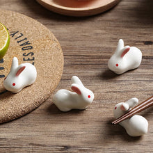 Load image into Gallery viewer, Enhance your Asian dining experience with our Ceramic Rabbit Chopstick Rests by Allthingscurated. These pieces will bring a playful edge to your table with their ability to keep your chopsticks clean and secure. Comes in a set of 3 or 6 pieces.